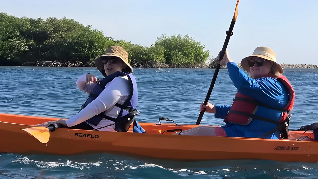 Two guests paddling a tandem kayak through the mangrove channels on Aruba's south coast